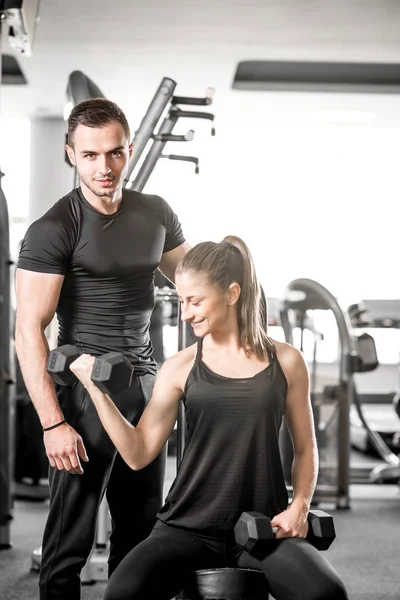 Onun kişisel antrenör ile spor salonunda pazı bukleler yapıyor kadın