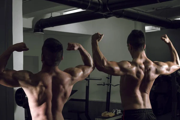 Dua orang menunjukkan tubuh di gym — Stok Foto