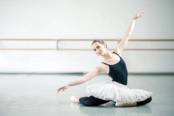 Bellerina sentada en el suelo en un estudio de ballet — Foto de Stock