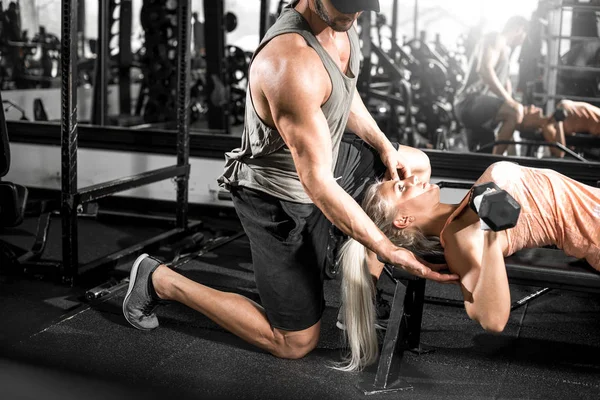 Vrouwelijke halter borstpres met hulp van persoonlijke trainer — Stockfoto