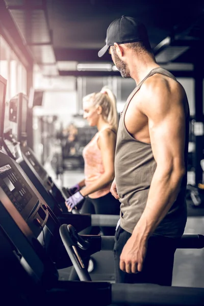 Koşu bandı üzerinde çalışan ve kıza baktığını çekici adam