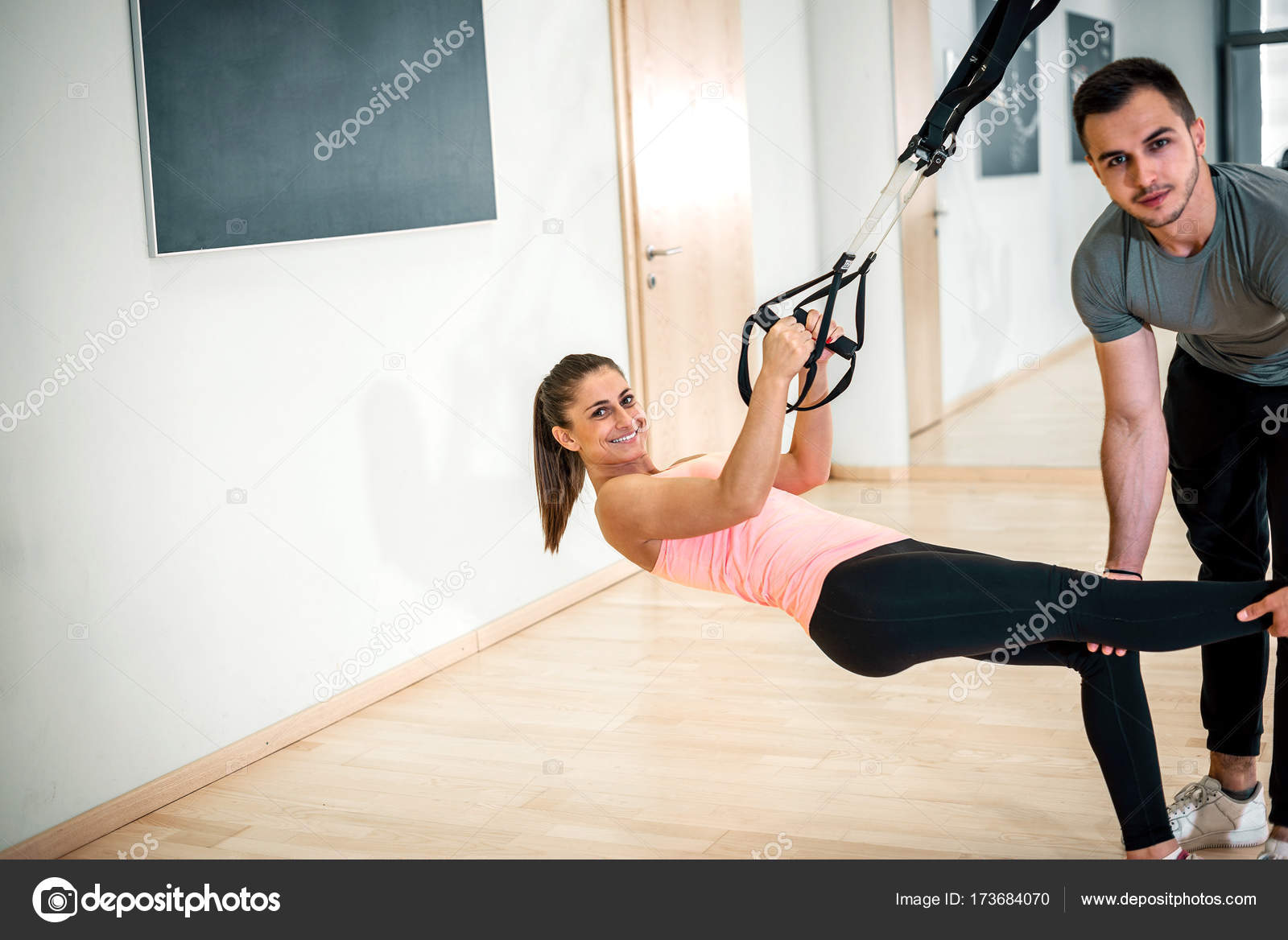 Suspension exercise with personal trainer. Stock Photo by ©ozimicians 173684070