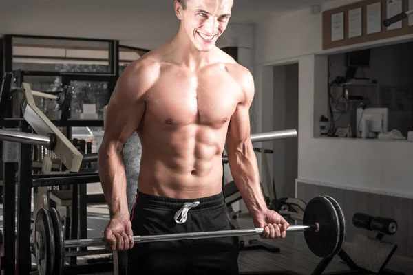 Hombre joven adulto levantando la barra — Foto de Stock