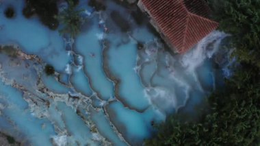 Tuscany İtalya 'daki Saturnia Termal Havuzu' nun hava aracı görüntüsü, üzerinde uçarken parlak doğal mineral havuzunun genel görünümü..