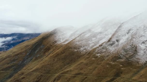 Horizontal landscape view of lightly snow dusted mountains in the clouds — 비디오