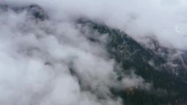 Aerial view. Flying over high mountain in beautiful clouds. — Stok video