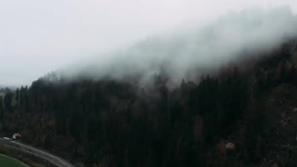 Aerial view. Flying sideways in front of big white clouds up in the mountains. — Stok video