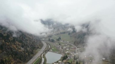 Mountain city in morning fog aerial landscape. Drone view misty haze, highlands landscape.