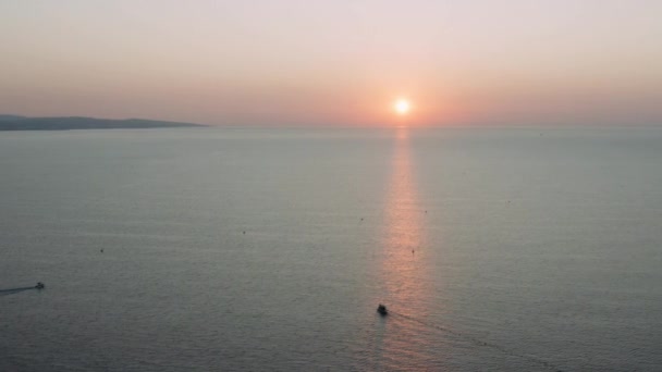 Drone shot of idyllic sea by mountains against sky during sunset — Stock videók