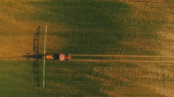 Luftaufnahme des Traktors, der das grüne Feld durch spezielle Installation bewässert. — Stockvideo