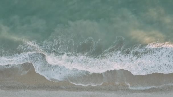 На песчаном побережье ломаются бирюзовые морские волны — стоковое видео