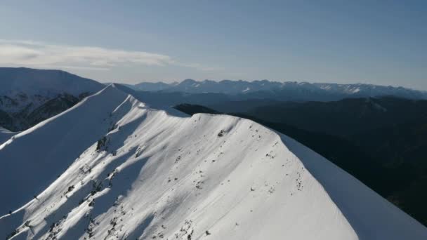 Ψηλά βουνά με χιονισμένες κορυφές. Εναέρια τοπίο χειμερινό βουνό. — Αρχείο Βίντεο