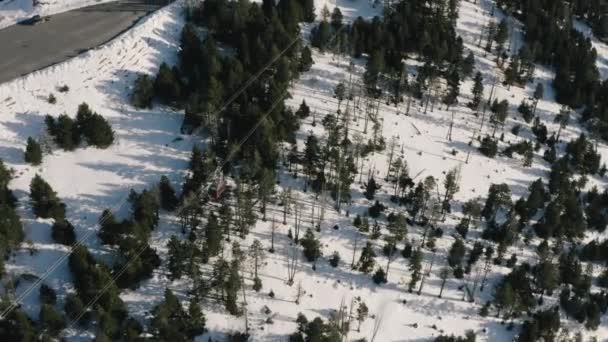 Skidlift rör sig på linbana rep på snöiga bergstoppar landskap. Flygfoto under utsikt ski hiss ridning på linbana på vintern resort. — Stockvideo