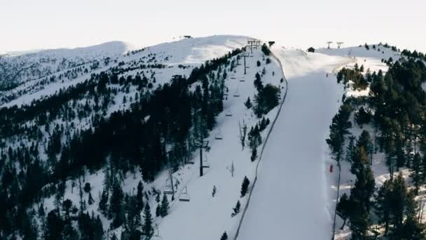 Flygfoto över skidbacken och de snöiga topparna i bergen mot den blå himlen, Andorra — Stockvideo