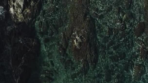 Vue aérienne sur le dessus vagues se brisent sur les roches sombres .