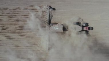 Yukarıdan bak, traktör tarlada çalışıyor. Çekirdekli bir traktör, tarlaya ekin ekmek. Tarım ürünleri ekiyorum. Büyük bir tarlada ekecek bir tohumu olan bir traktör..