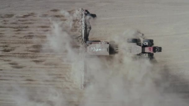 Vue d'en haut, tracteur travaillant dans un champ. Tracteur avec semoir, semer les cultures au champ. Semis de cultures agricoles. Tracteur avec semoir à semer dans un immense champ . — Video