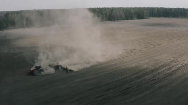 Αεροφωτογραφία του ελκυστήρα σπέρνει σπόρους σε ξηρό έδαφος στο πεδίο αφήνοντας πίσω σύννεφο σκόνης. — Αρχείο Βίντεο
