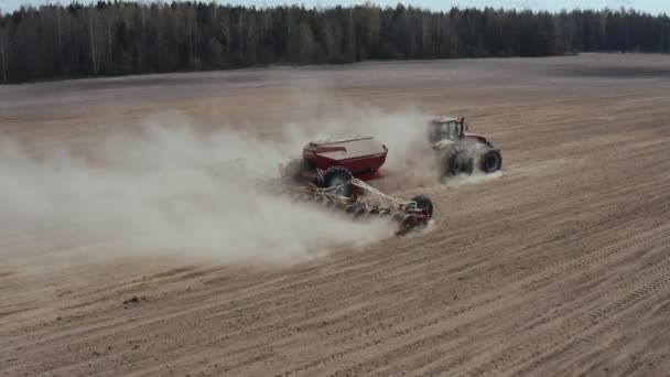 Letecký pohled na zemědělský traktor osévající zemědělské plodiny na poli. Zemědělské stroje setí plodin na poli. — Stock video
