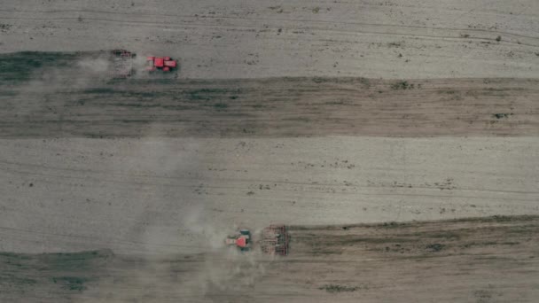 Traktory v prachu pracující v terénu. Zemědělci setí plodin na poli. — Stock video