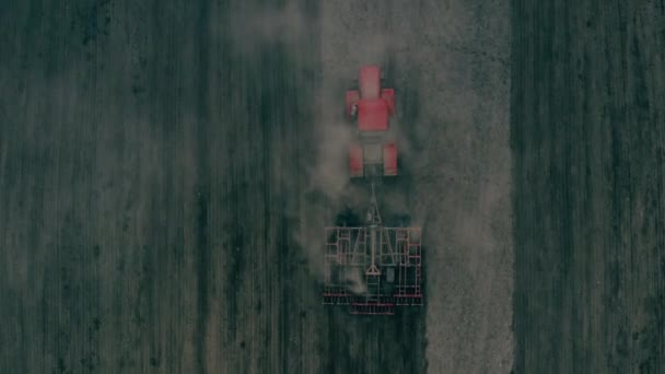 Tracteur avec une charrue rouge pendant les travaux sur un champ agricole au Bélarus — Video