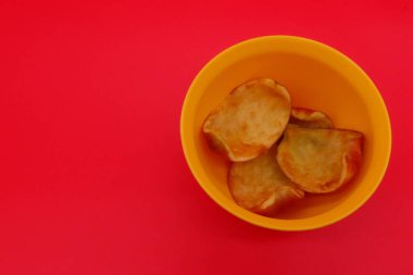 Elma kabukları kırmızı arkaplanda izole edilmiş. Gübreleme için meyve atıkları. Meyve artıkları. Karbon ayak izi azaltılıyor. Bahçe konsepti.