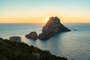 Güneşin Es Vedra 'da Torre del Savinar ile birlikte batışının göz kamaştırıcı manzarası Es Vedra, Sant Josep de Sa Talaia, İbiza, İspanya.