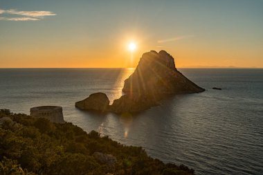 Güneşin Es Vedra 'da Torre del Savinar ile birlikte batışının göz kamaştırıcı manzarası Es Vedra, Sant Josep de Sa Talaia, İbiza, İspanya.