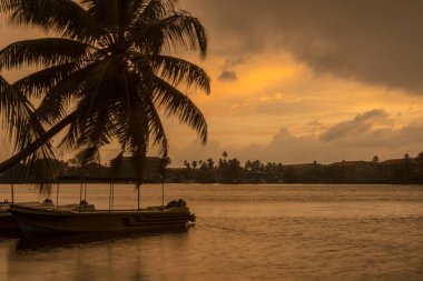 Güneş Bentota nehri üzerinde, Galle bölgesinde, Sri Lanka 'da bulutsuz bir gökyüzünün altında son derece sakin bir günde doğuyor. Bentota, Sri Lanka.