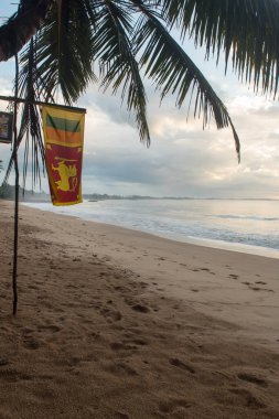 Tangalle, Sri Lanka: 2020 Kasım 25: Tangalle, Sri Lanka sahilinde Sunset 'te bayrak.