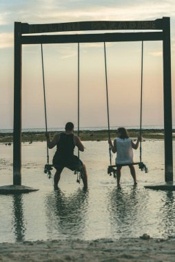 Endonezya 'dan Gili Trawangan. : 2018 3 Mayıs: Endonezya 'da Gili Trawangan' ın salıncaklarında genç bir çift.