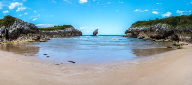 Güneşli bir günde Rocky sahili. Kıyı manzarası, vahşi doğa, küçük resim koyları, denizde güzel kayalar. Playa de Buelna, Asturias, İspanya