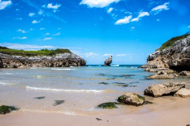 Güneşli bir günde Rocky sahili. Kıyı manzarası, vahşi doğa, küçük resim koyları, denizde güzel kayalar. Playa de Buelna, Asturias, İspanya
