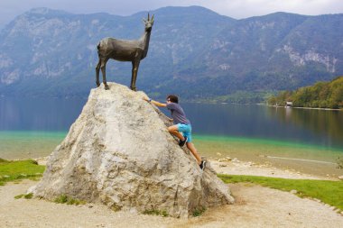 Slovenya 'nın Bohinj gölündeki kayaya tırmanan genç adam