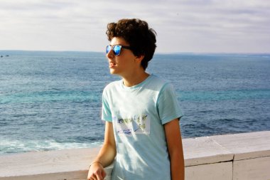 Yakışıklı çocuğun portresi San Diego La Jolla Plajı 'nda kameraya gülümsüyor.