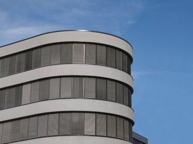 Pencereleri perdeli yuvarlak bir bina.