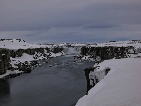 A long time exposure of the Dettifoss Waterfall with snow