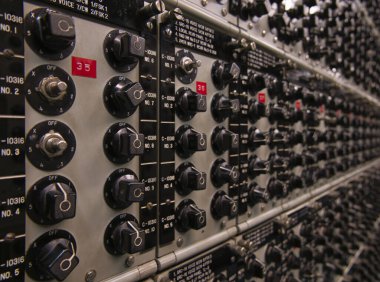 Bir kontrol odasında sayısız işletim paneli ve döner kontroller.