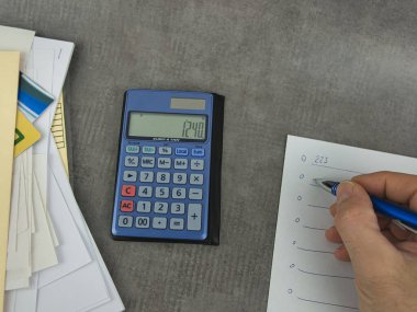 Belgeleri olan bir hesap makinesi ve yazmak için bir not defteri