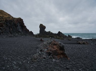 İzlanda sahilinde renkli volkanik kayalar ve siyah çakıl taşları