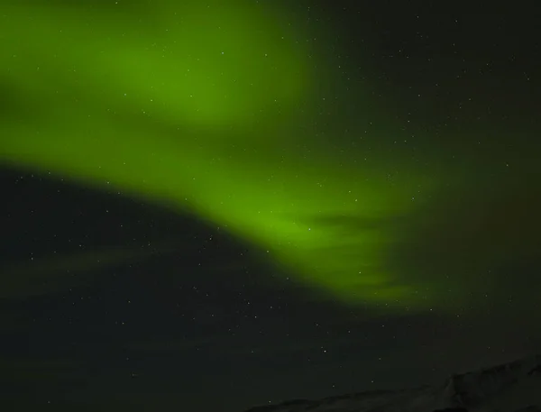 多くの星とアイスランドの山脈の上の大きな極の光 — ストック写真