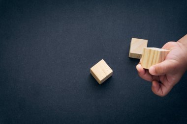 Tahta küp alfabesi yakın çekim ve çocukların elleri siyah arkaplanda. Seçici odaklanma ve eğitim kavramı