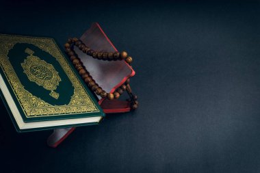 El-Kur 'an' ın Arapça el yazısı ve tasbih 'in ya da siyah arkaplanda tespih boncuğunun yazılı olduğu Kutsal Kur' an. Seçici odak ve kırpma parçası