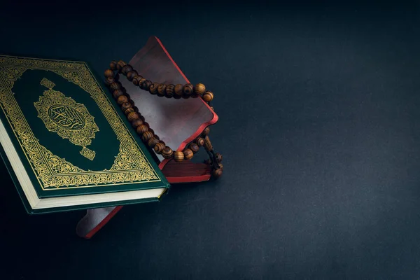 El-Kur 'an' ın Arapça el yazısı ve tasbih 'in ya da siyah arkaplanda tespih boncuğunun yazılı olduğu Kutsal Kur' an. Seçici odak ve kırpma parçası