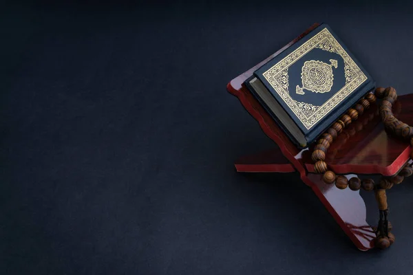 El-Kur 'an' ın Arapça el yazısı ve tasbih 'in ya da siyah arkaplanda tespih boncuğunun yazılı olduğu Kutsal Kur' an. Seçici odak ve kırpma parçası