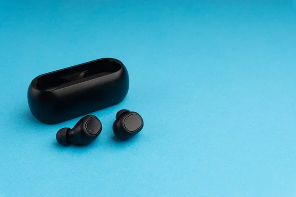 Wireless earbuds or earphones on blue background