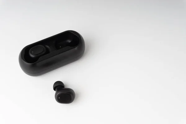 Wireless earbuds or earphones on white background. Copy space and technology concept