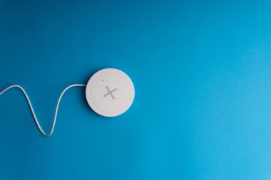 Mavi arkaplanda şarj pedi ya da rıhtım. Kablosuz şarj ve kopyalama alanı 