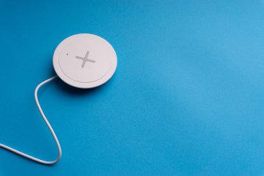 Mavi arkaplanda şarj pedi ya da rıhtım. Kablosuz şarj ve kopyalama alanı 