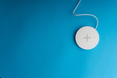 Mavi arkaplanda şarj pedi ya da rıhtım. Kablosuz şarj ve kopyalama alanı 